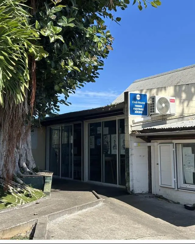 Le club-house du club, sous un grand banian, avec son panneau d'entrée.