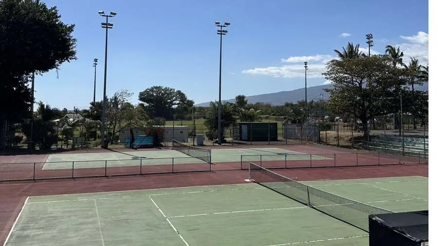 Les quatre terrains en dur du club, avec les montagnes de La Réunion à l'horizon.